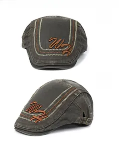 Detail of vintage charcoal cotton flat cap with brown W embroidery and contrast stitching