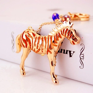 Gold-tone zebra horse keychain with blue beads and intricate hollow-out detailing