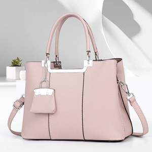 Pale pink lychee grain leather handbag with silver hardware and mini charm accessory