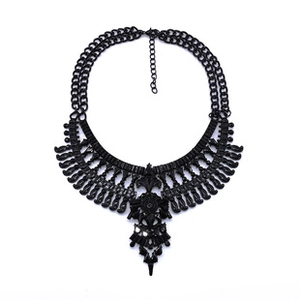 Detailed flat lay of a gothic black statement necklace with floral geometric charms
