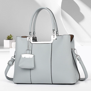 Detailed texture of light grey-blue lychee grain leather with silver U-shaped metal decor
