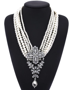 Close-up of multilayer pearl necklace with grand crystal encrusted drop pendant