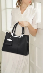 Detail of black lychee grain leather handbag with silver U-shaped metal hardware