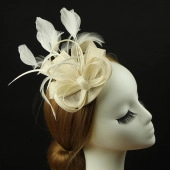 Detail of beige fascinator hat with elegant feather decoration and woven bow design