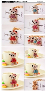 Detail showing various colors of rhinestone bear keychains with golden lobster clasps