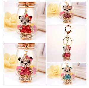 Detail of rhinestone bear keychains in red and blue dresses with gold metal hardware