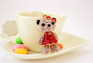 Detailed close-up of a sparkling rhinestone bear pendant hanging on a white ceramic cup