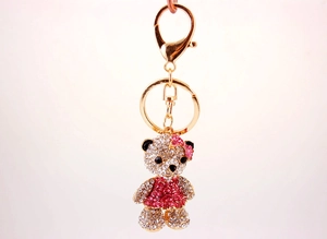 Macro detail of golden teddy bear keychain with pink and clear crystal rhinestones