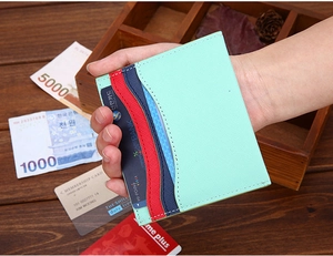 Close-up of mint green slim card holder showing multi-layer card slots in hand