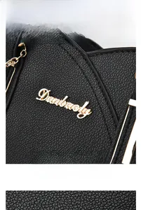 Close-up of golden Danbaoly logo on black lychee grain leather tote bag detail