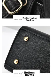 Detail view of gold metal buckles and protective bottom rivets on black leather handbag