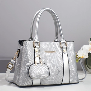 Detail of silver snakeskin textured tote bag with detachable mini pouch and gold hardware