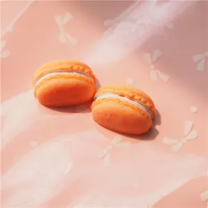 Macro shot of orange resin macaron charms with white cream filling for DIY crafts