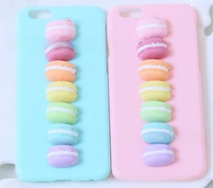 Detail of colorful resin macaron charms on pink and blue matte phone cases