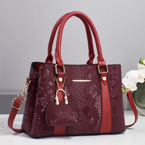 Elegant burgundy snakeskin textured handbag with top handle and matching mini pouch pendant