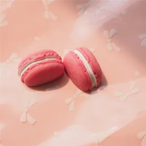 Macro shot of two bright pink resin macarons with white cream filling for DIY crafts