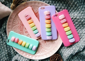 Macro view of 3D miniature macaron resin charms on colorful smartphone cases