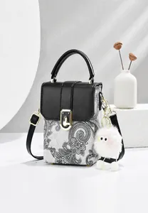 Detail der Paisley-Handtasche mit schwarzer Lederklappe und goldenem Drehverschluss