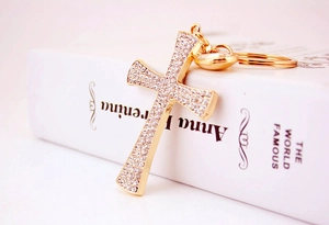 Detailed macro view of a golden cross keychain featuring sparkling inlaid rhinestones