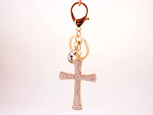 Close-up of golden cross keychain with sparkling rhinestones and crystal teardrop pendant
