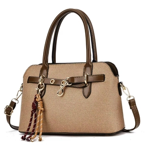 Sac à main tissé beige avec garniture en cuir marron et décor de pompons colorés