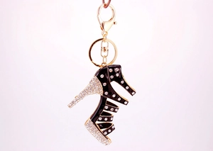 Detail of creative black enamel high heel keychain with sparkling rhinestones and gold clasp
