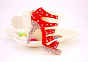 Close-up of red high heel keychain with sparkling crystals and gold metal edges