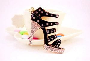 Macro view of crystal high heel keychain with black enamel finish and gold metal accents