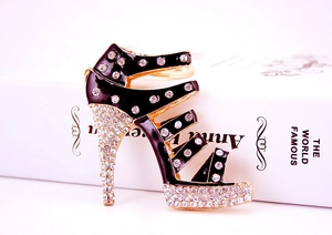 Detail of a sparkling gold high heel keychain with black enamel and clear rhinestones