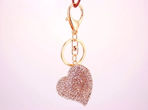 Close-up of heart keychain with pink rhinestones and gold-plated metal hardware