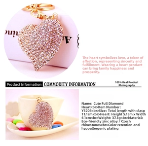 Detail of heart-shaped keychain with white rhinestones and gold-plated metal clasp