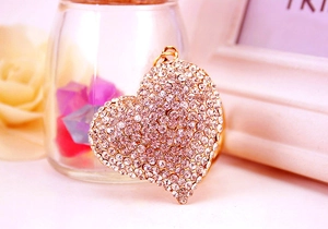 Detailed macro view of heart pendant with sparkling white rhinestones and gold metal