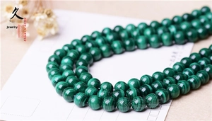 Macro shot of natural green malachite round beads with unique striped textures