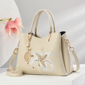 Elegante beige PU-Leder Handtasche mit Lilienstickerei und Goldblatt-Perlenanhänger