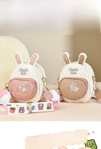 Detail of soft leather backpack with bunny embroidery and decorative fluffy charms