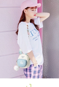 Side view of white and blue crossbody bag with bunny ears and plush pom pom