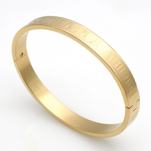 Detail of Roman numeral engravings on a gold-tone stainless steel hinged couple bracelet