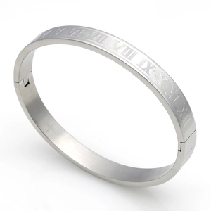 Macro detail of silver titanium steel bangle with engraved Roman numerals and brushed finish