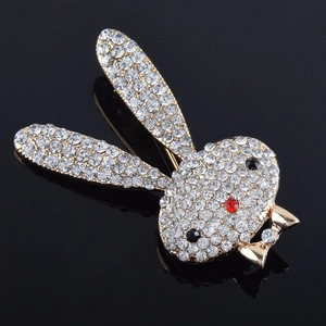 Detailed close-up of rabbit brooch with gold base and sparkling clear rhinestones