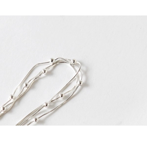 Macro shot of multi-layered S925 sterling silver beaded snake chain bracelet detail