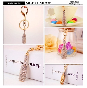 Detailed close-up of sparkling rhinestone champagne bottle keychain with gold lobster clasp