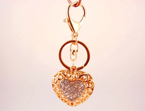 Macro view of golden heart pendant with crystal inlay and hollow-out edge details