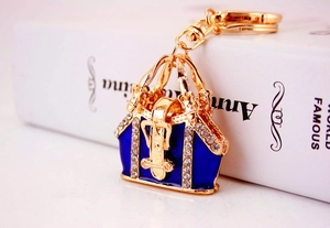 Detailed macro view of handbag keychain with blue enamel and sparkling rhinestones
