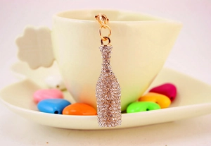 Close-up of a sparkling gold beer bottle keychain with inlaid crystal rhinestones