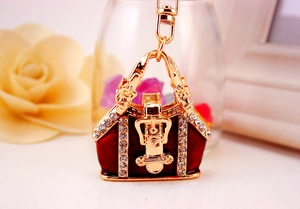Detail of a gold handbag keychain with red enamel coating and sparkling crystal rhinestones