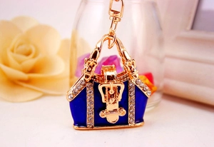 Detailed close-up of a royal blue enamel handbag keychain with sparkling rhinestones and gold trim