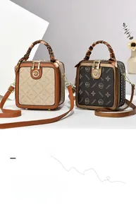 Détail du sac à main carré avec texture monogramme et poignée ornée d'un foulard en soie
