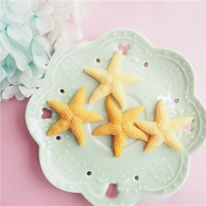 Macro detail of resin starfish charms with realistic texture in gradient yellow colors