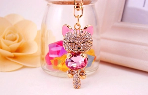 Close-up of crystal lucky cat keychain with pink gemstone and gold lobster clasp