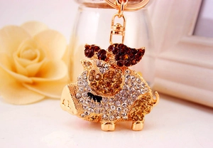 Close-up of golden flying pig keychain with sparkling crystals and lobster clasp detail